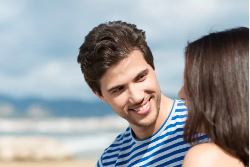 young handsome man listening to his girlfriend outdoors