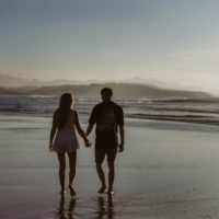 man and woman holding hands while walking on water