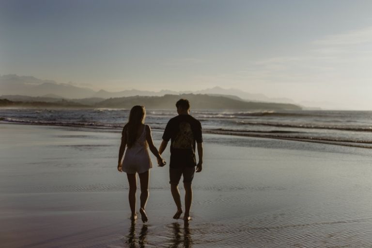 hombre y mujer cogidos de la mano caminando sobre el agua