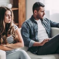 angry woman and man sitting on sofa