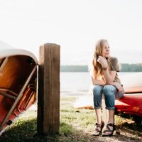 mulher com relógio sentada num barco vermelho