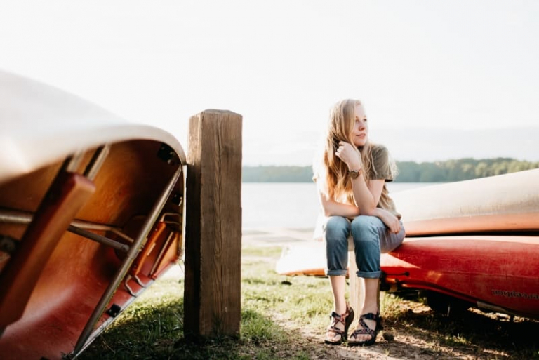 mulher com relógio sentada num barco vermelho