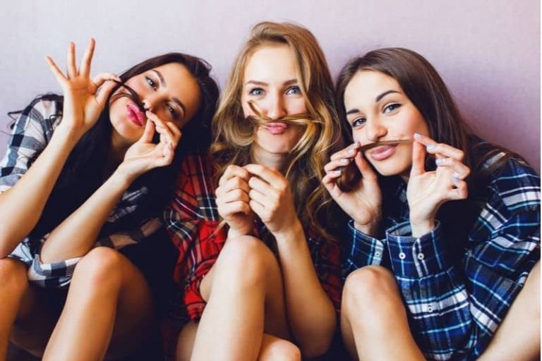 três amigas a divertirem-se com uma sessão fotográfica no interior de um edifício
