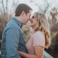 smiling man and woman making eye contact while standing outdoor