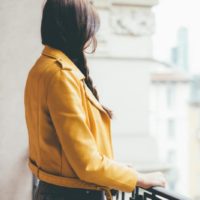 vista posteriore di una donna caucasica che guarda fuori attraverso la veranda