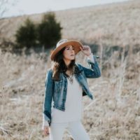 mujer con sombrero de pie en el campo