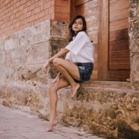 woman in white shirt sitting near door