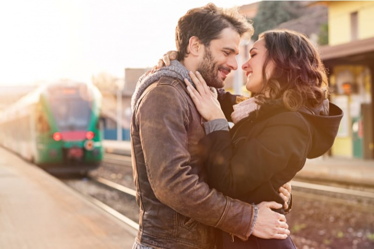 pareja sonriente abrazándose al aire libre