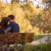man and woman sitting on bench