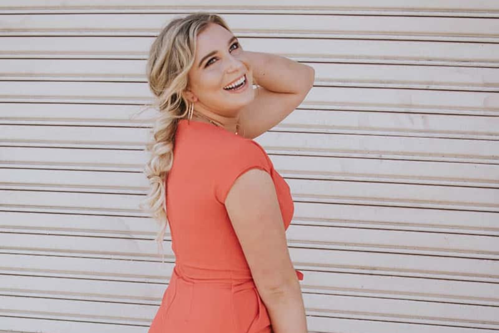 blonde woman in orange dress smiling