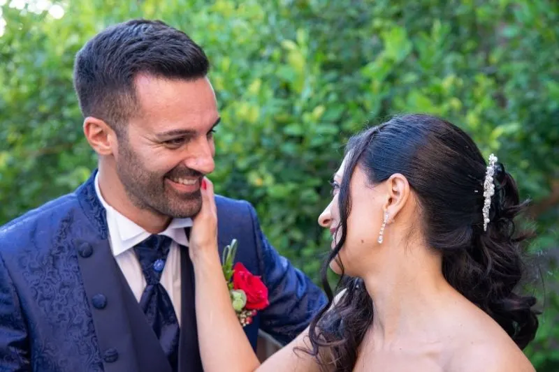 close up photo of couple laughing wearing formal wear outdoors