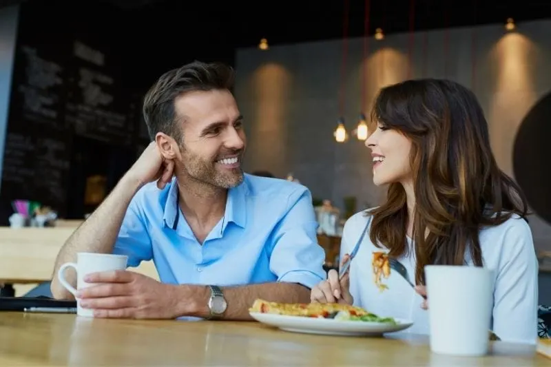 couple at cafe talking while eating 