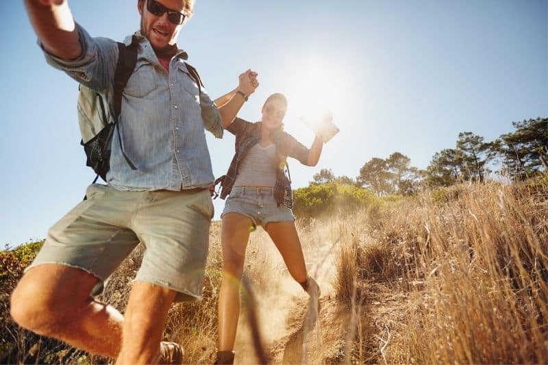 casal a divertir-se durante uma caminhada de aventura na montanha