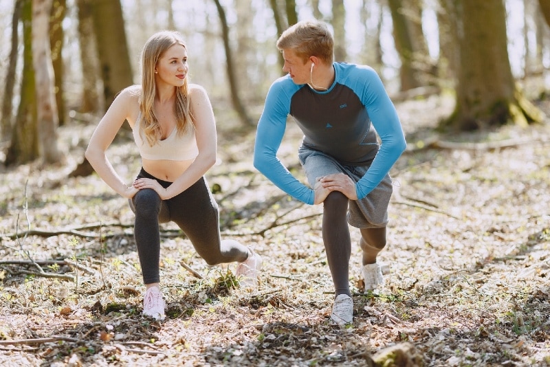 man and woman exercising while looking at each other outdoor