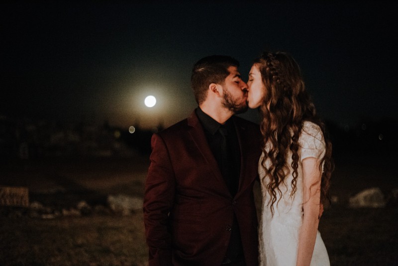 man and woman kissing at night