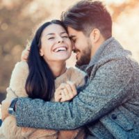 pareja riendo al aire libre hombre abrazando a la mujer