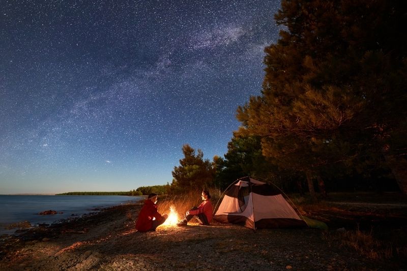 couple night camping near the body of water 