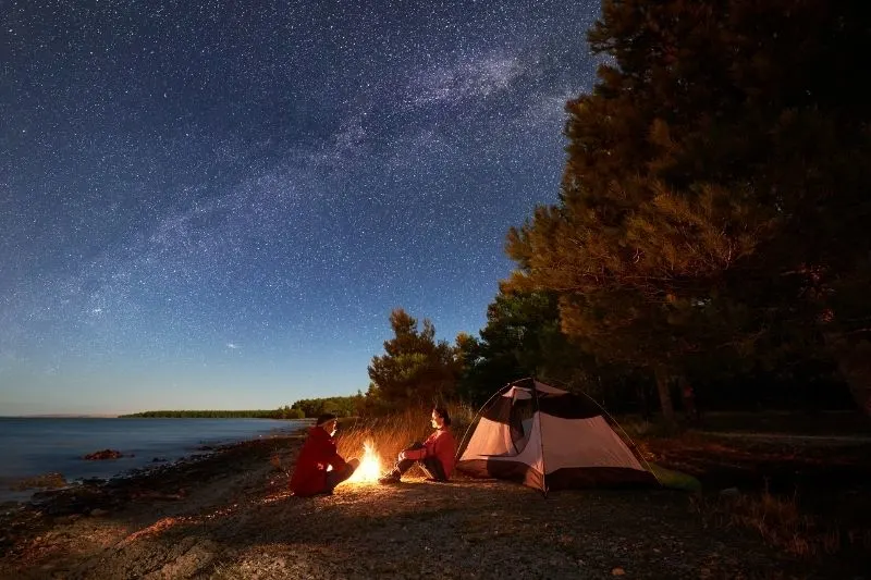 couple night camping near the body of water 
