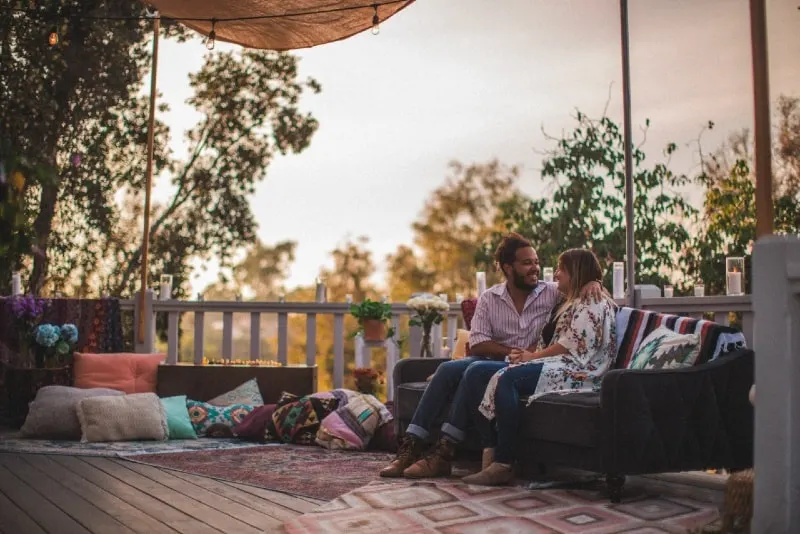 man and woman sitting on couch an talking outdoor