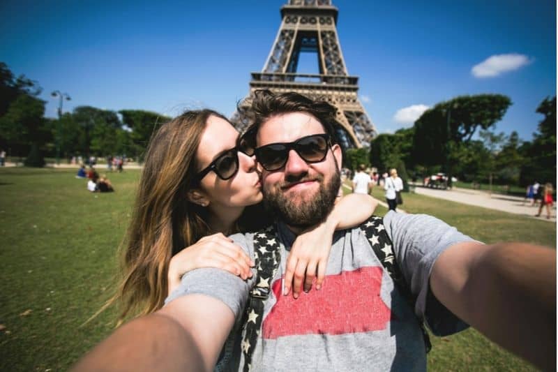 pareja fotografiándose en la torre Eiffel de Francia 