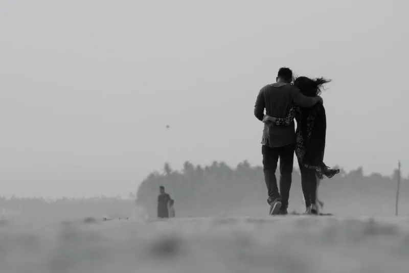 man and woman hugging while walking