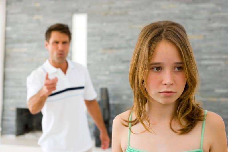 critical father reprimanding his daughter inside home
