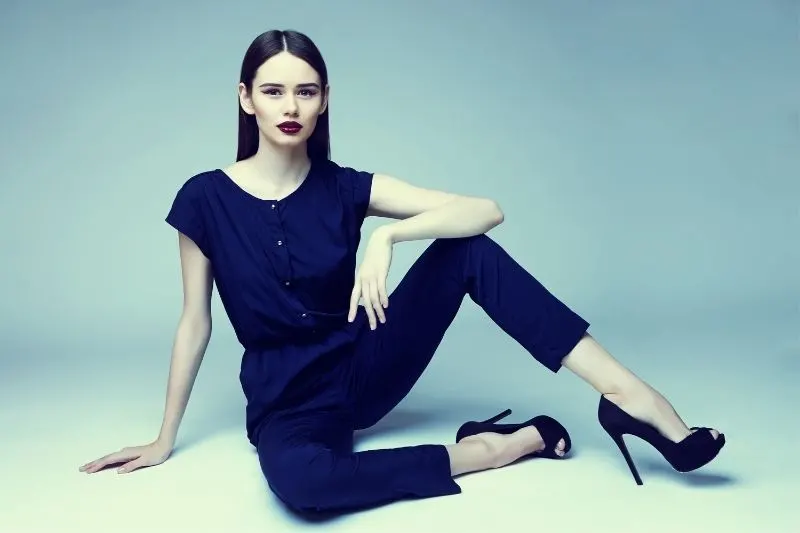 fashionable woman sitting on the floor wearing blue high heels and red lipstick with blue casual wear
