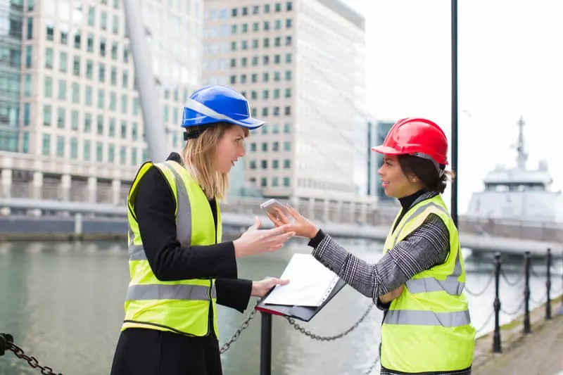 female engineers discussing over the cellphone on site location