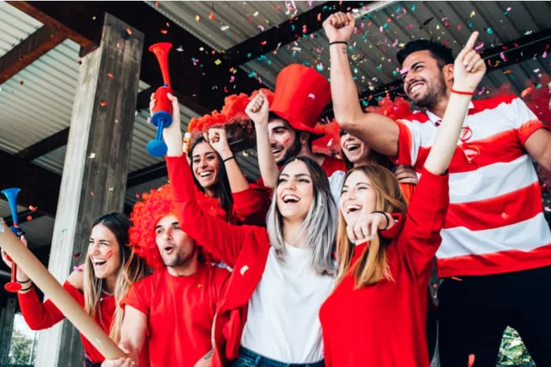 football fans cheering and supporting their team in the arena