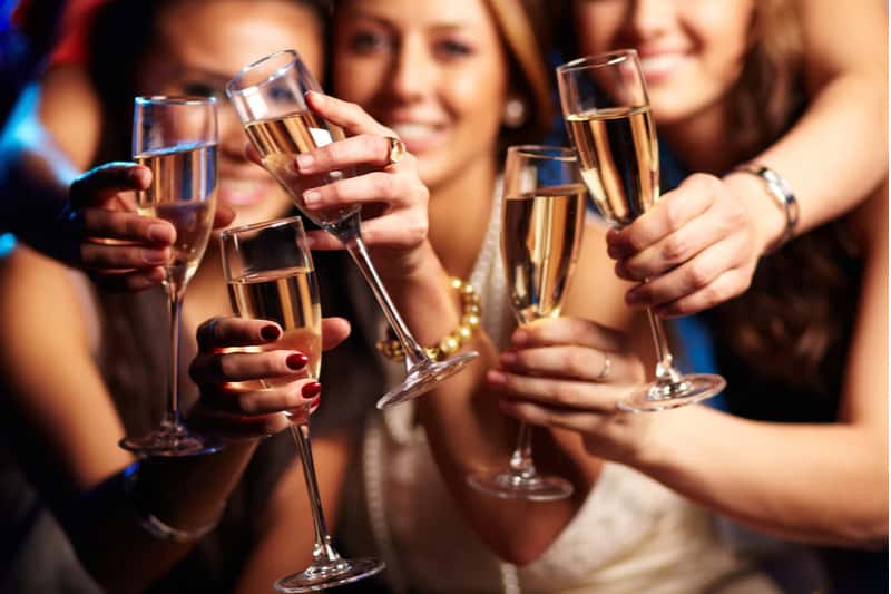 group of partying girls clinking flutes sparkle
