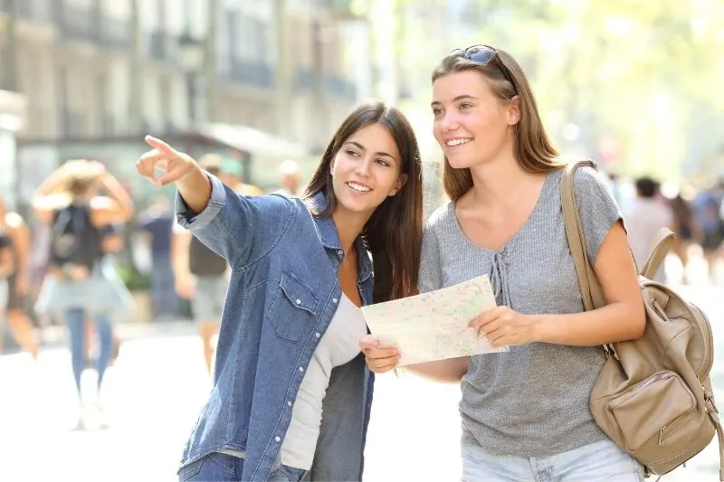 happy girl helping a traveller find the location she was looking