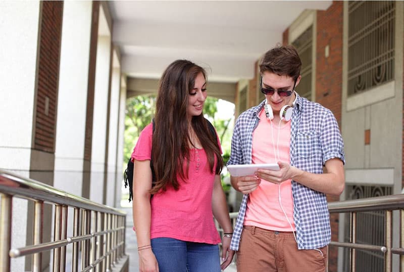 estudiantes de secundaria hablando dentro del campus sobre el gadget