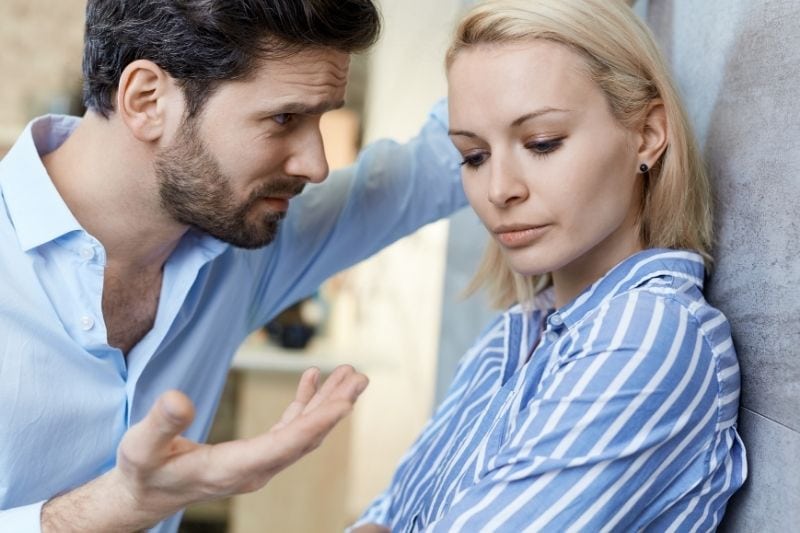 hostile couple fighting with man attacking the silent woman leaning on the wall