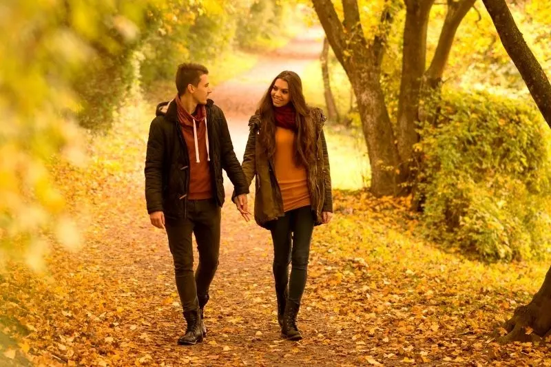 lovers walking holding hand in the middle of the autumn park