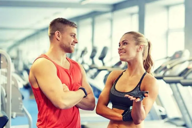 man and woman in the gym talking wearing athletic wear