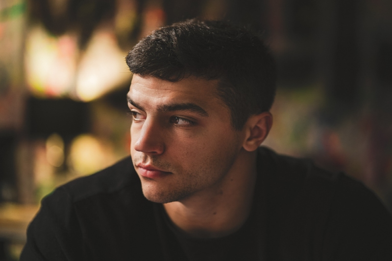 man in black sweatshirt sitting indoor