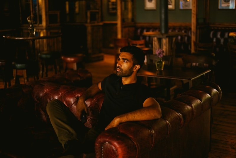 man in black shirt sitting on sofa