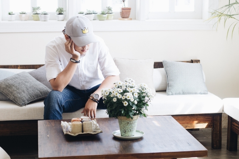 man in white shirt sitting on sofa near coffee table