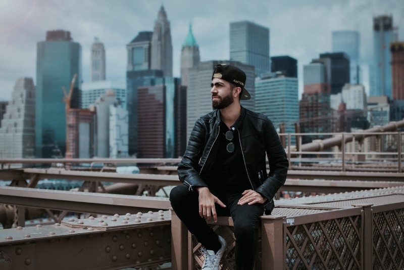 man in black jacket sitting on steel construction