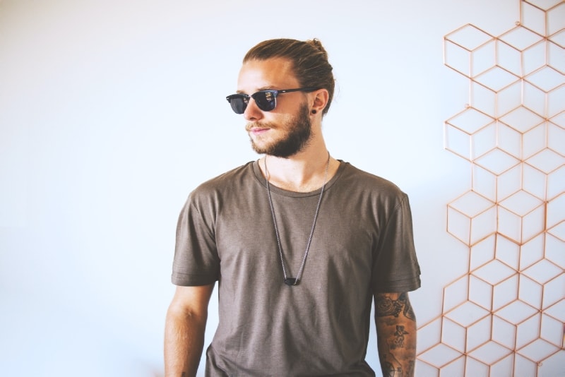 man with sunglasses standing near wall