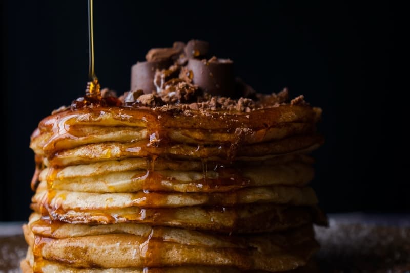 pile of pancakes with honey