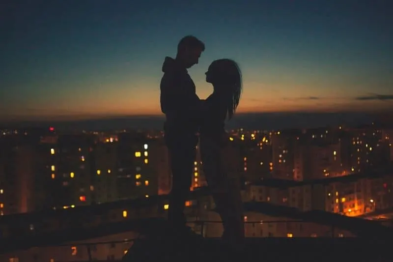 silhouette of a couple with the city as the background
