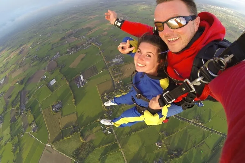 woman in blue jacket and man doing sky diving