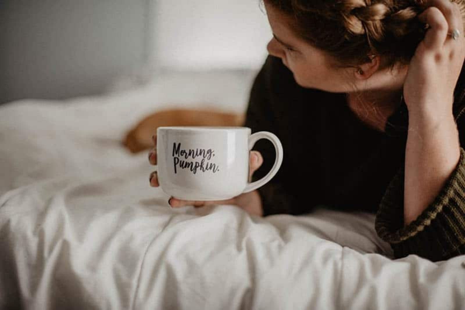 mulher a beber o seu café matinal na cama