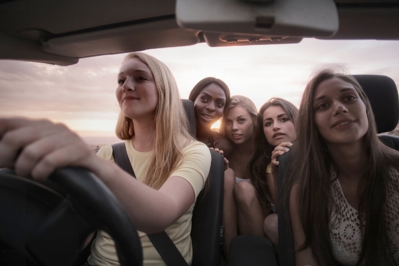 mujer conduciendo coche con sus amigas