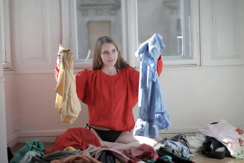 woman in red shirt holding her clothes