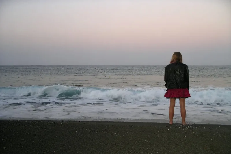 woman standing on seashore looking at sea