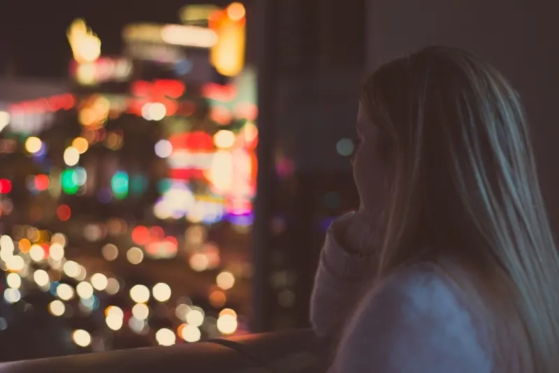 blonde woman looking outside at night