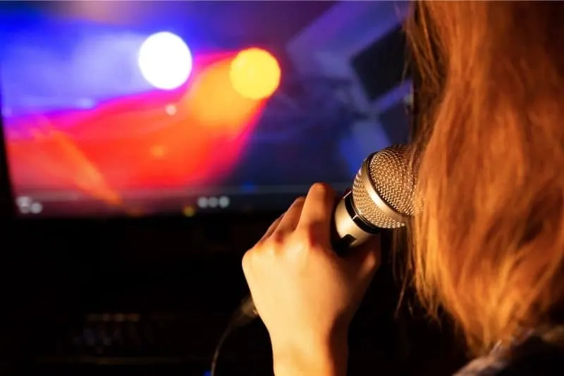 woman singing karaoke alone during a self quarantine