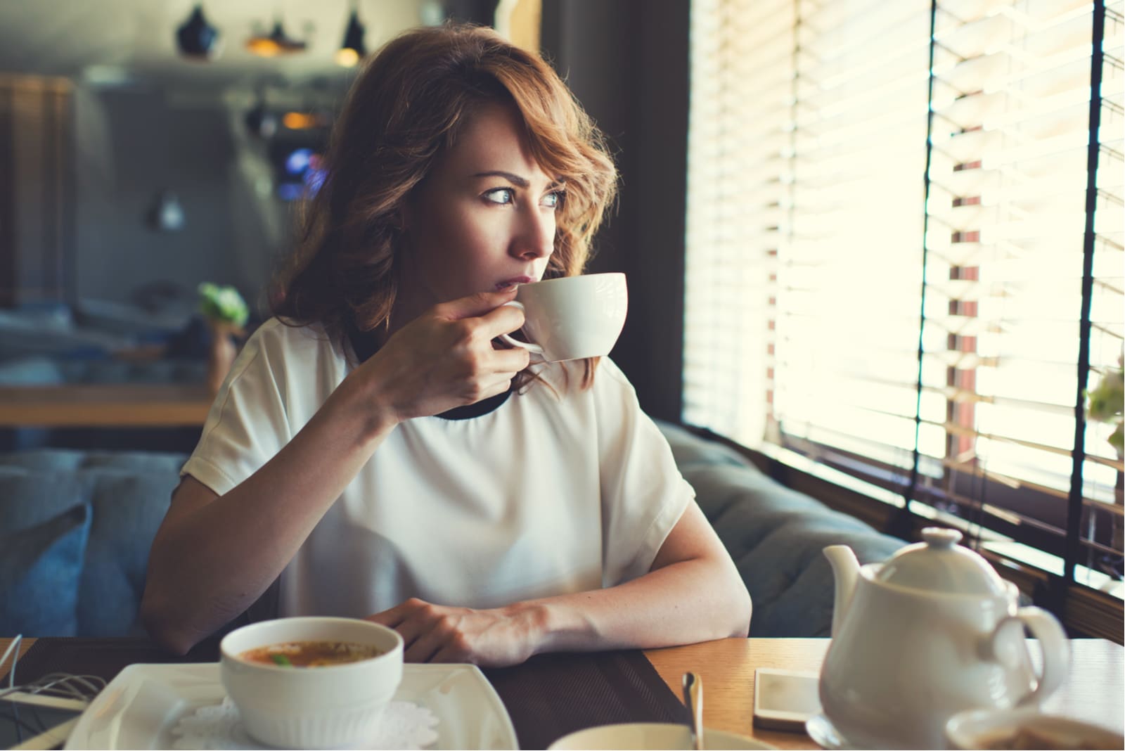 mulher sentada num café a beber café